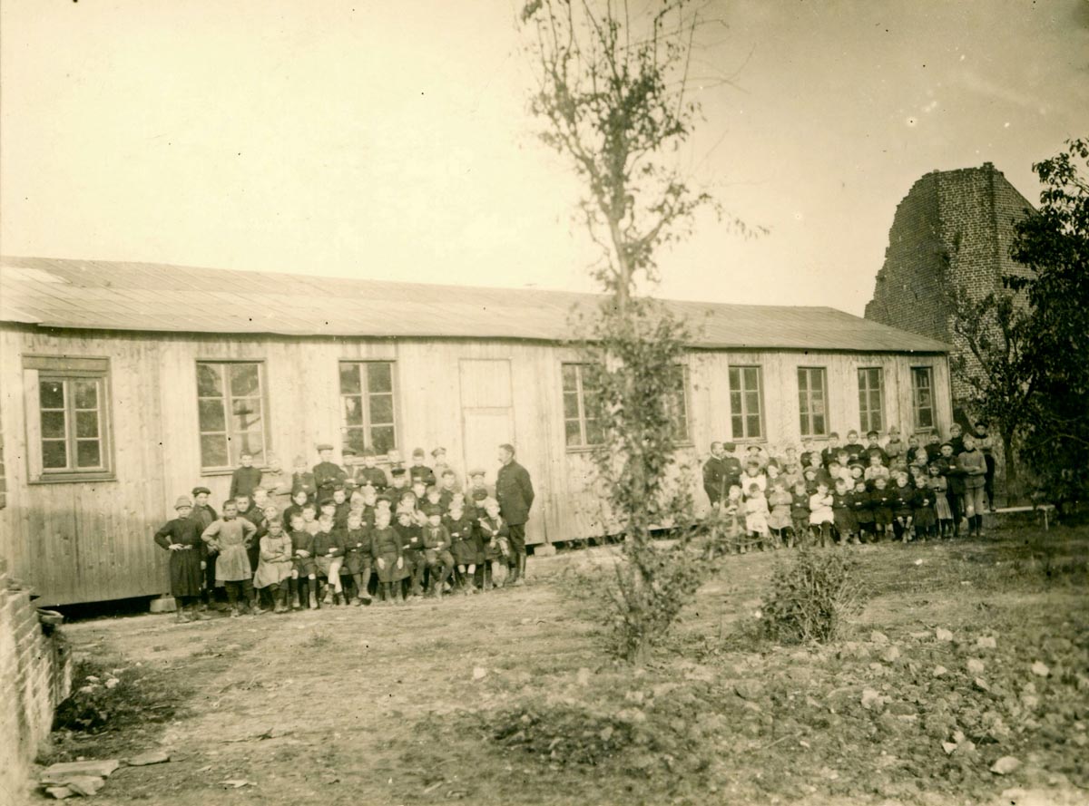 Photo de classe dans la cour de l'école provisoire privé de Quesnoy. Archives municipales de Quesnoy-sur-Deûle - 5QSD_Z713